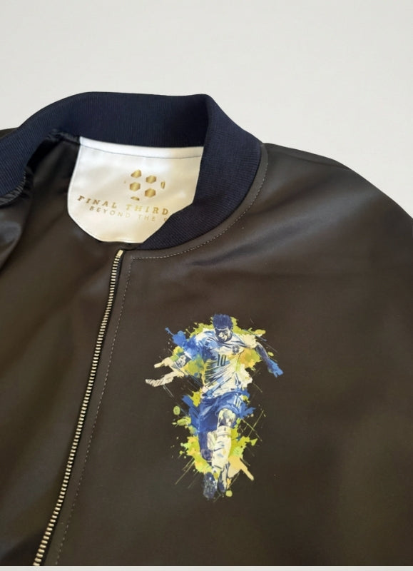 Black bomber jacket with colorful graphic design on a light gray background