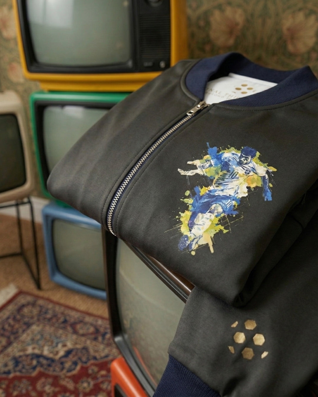 Black jacket with colorful design on a vintage television set