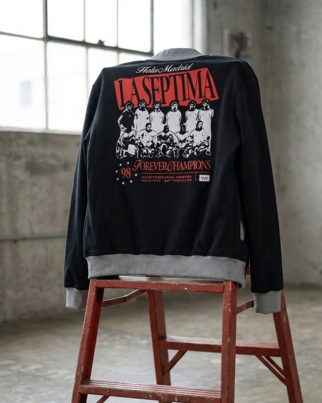 Black jacket with graphic design on a red stool against a concrete wall.