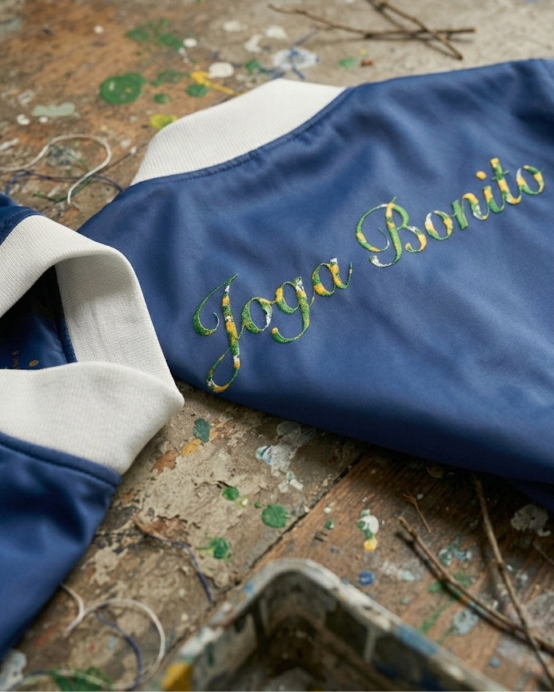 Blue fabric with 'Joga Bonito' embroidery on a textured surface