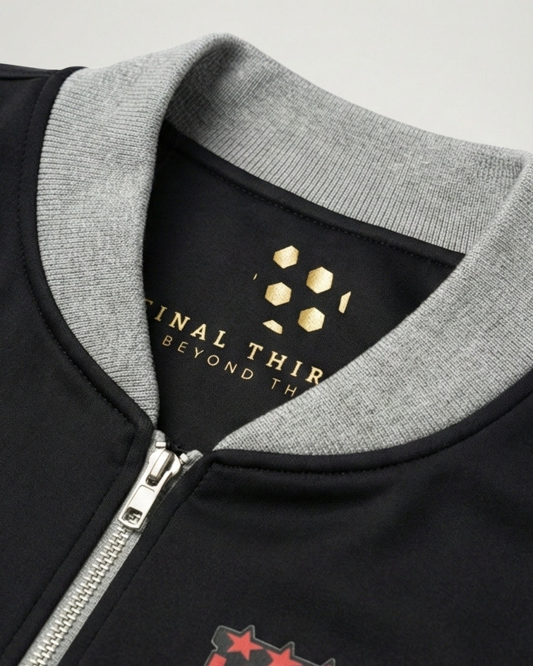 Close-up of a black jacket with gray collar and zipper, featuring a brand logo.