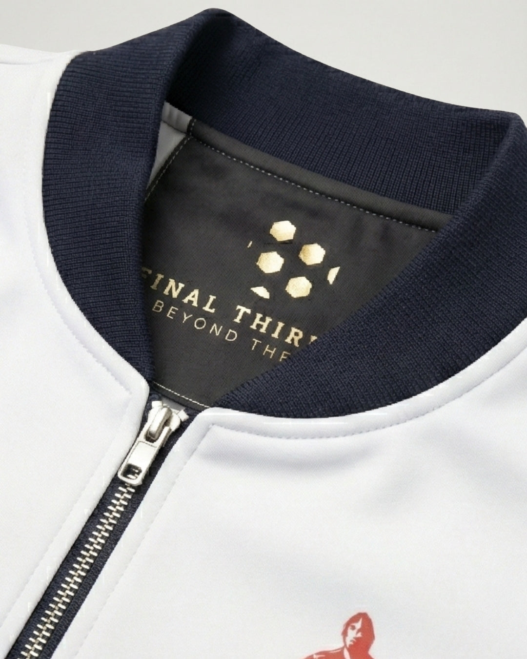Close-up of a white jacket with navy collar and brand logo on a light gray background